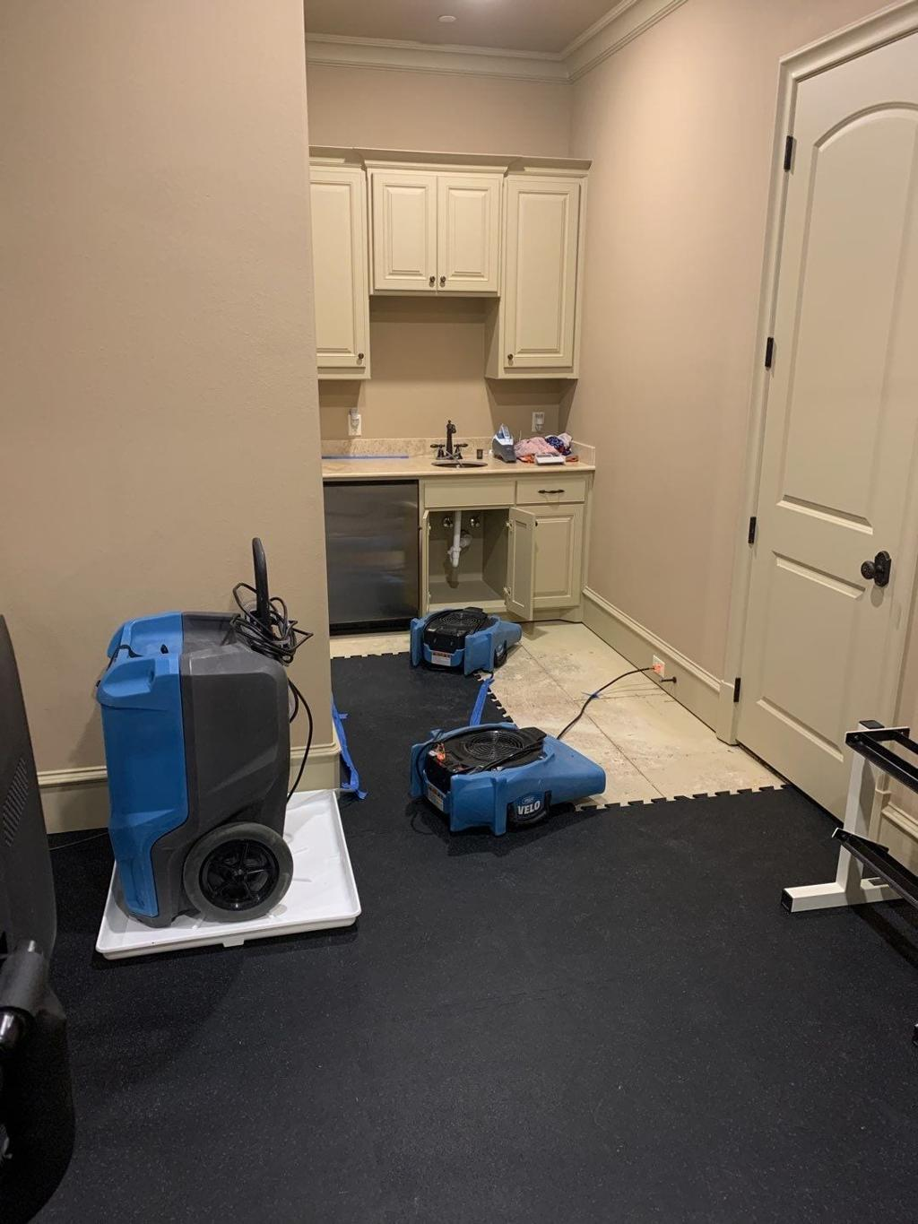 Air movers and dehumidifier drying a room